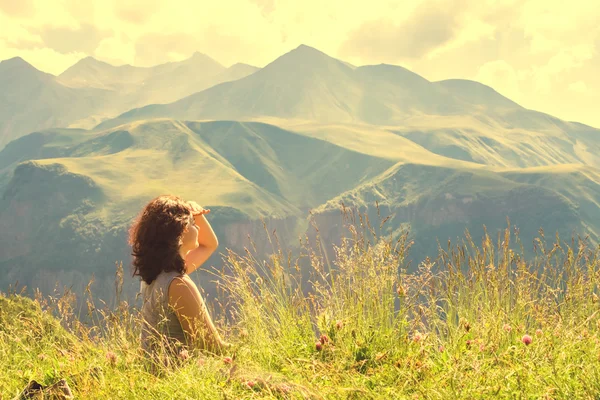Žena sedí na vrcholu hory — Stock fotografie