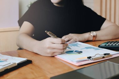 Kadın yönetici, iş planlarını işyerine koyuyor, elinde kalemler ve kağıtlar tutan adam, belgelerle notlar tutuyor, ofisteki masanın üzerine yazıyor..