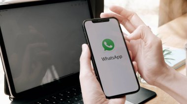 CHIANGMAI. Tayland. 4 Mayıs 2021. Yeni iPhone 11 Pro Max 'i elinde tutan bir kadın ellerinde akıllı telefonuyla ekranda sohbet teknolojisinde ne konuşuyorsa onu açıyor.