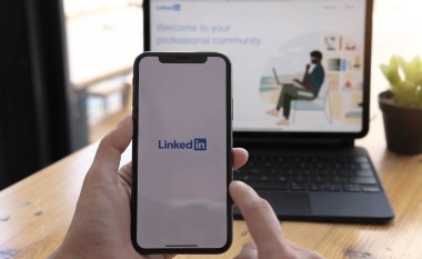 CHIANGMAI, THAILAND MAR 21 2021: iPhone X veya iPhone 10 'u elinde tutan sosyal internet servisi ekrana bağlanmış kadın