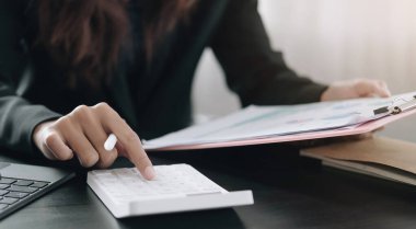 Matematik finansmanı için hesap makinesi ve dizüstü bilgisayar kullanan iş kadını ofis ve iş geçmişinde, vergi, muhasebe, istatistik ve analitik araştırma kavramında kapat
