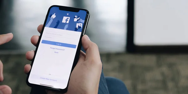 CHIANG MAI, THAILAND JAN 6 2021: Жінка тримає iPhone X з соціальною інтернет-службою Facebook на екрані. — стокове фото