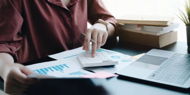 Matematik finansmanı için hesap makinesi ve dizüstü bilgisayar kullanan iş kadını ofis ve iş geçmişinde, vergi, muhasebe, istatistik ve analitik araştırma kavramında kapat