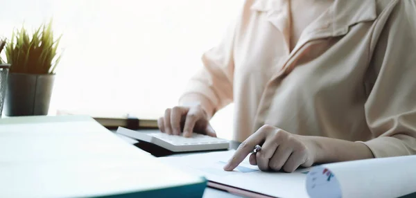 Close up Mujer de negocios que utiliza la calculadora y el ordenador portátil para hacer finanzas matemáticas en escritorio de madera en la oficina y el negocio de trabajo fondo de impuestos estadísticas contables y el concepto de investigación analítica —  Fotos de Stock