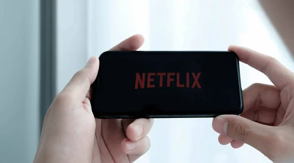 CHIANG MAI, THAILAND, MAR 25 , 2021: Woman hand holding Smart Phone with Netflix logo on Apple iPhone Xs. Netflix is a global provider of streaming movies and TV series. — Stock Photo, Image