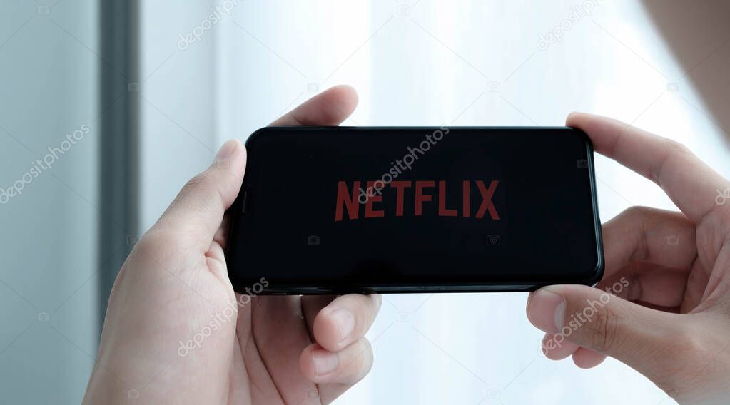CHIANG MAI, THAILAND, MAR 25 , 2021: Woman hand holding Smart Phone with Netflix logo on Apple iPhone Xs. Netflix is a global provider of streaming movies and TV series..