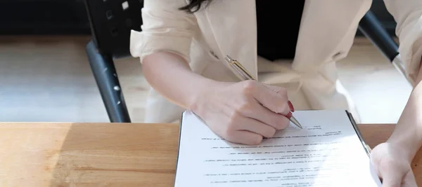 Pośrednik w obrocie nieruchomościami pomagający klientowi w podpisaniu umowy na biurku z modelką domu — Zdjęcie stockowe