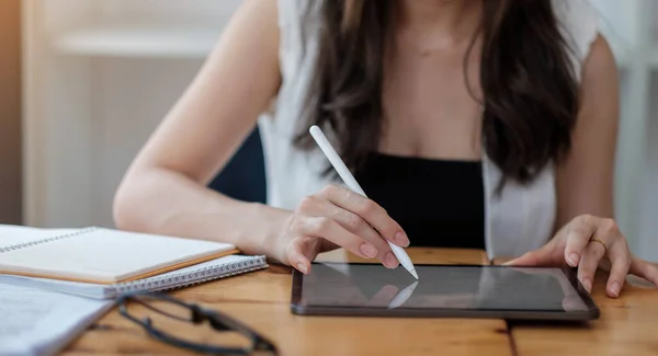 上图是女性在办公室桌上拿着数字平板电脑和笔尖笔的照片 产品显示蒙太奇的空白屏幕 — 图库照片
