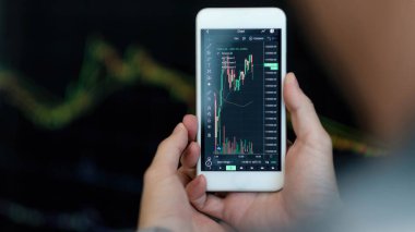 İş adamı tüccar yatırımcı analisti şifreli para birimi finans piyasası analizi için cep telefonu uygulama analizi kullanıyor, akıllı telefon üzerinde veri indeksi grafiği ticareti.