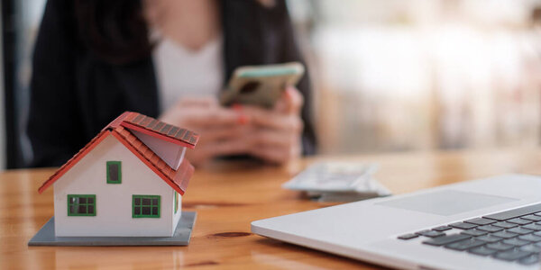 Агент по недвижимости с домовой моделью руки положить подписание контракта, иметь контракт на месте, чтобы защитить его, подписание скромных договоров формы в office.