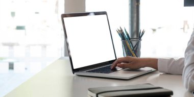 Modern ofis içerisinde boş ekran dizüstü bilgisayar ve poster çalışma alanı arkaplanı