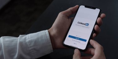 CHIANG MAI, THAILAND, DEC 12, 2020: Bir kadın ekranda LinkedIn uygulaması ile Apple iPhone X tutuyor. LinkedIn akıllı telefonlar için fotoğraf paylaşım uygulaması