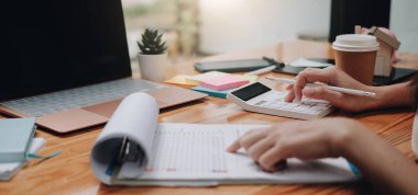 Finans, vergi, muhasebe, istatistik ve analitik araştırma konseptini hesaplamak için hesap makinesi ve dizüstü bilgisayar kullanan İşadamı kapat