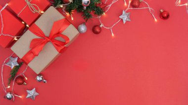 Güzel paketlenmiş hediyeler, süsler ve peri ışıkları içeren canlı kırmızı bir arkaplan. Tatil temalı tasarımlar için mükemmel..