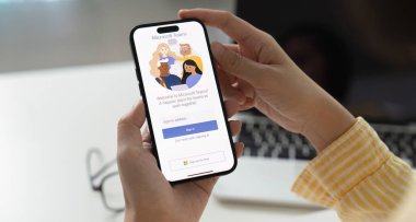 CHIANG MAI, THAILAND - 11 APR 2025: Evdeki çalışanlardan biri, evden izole bir şekilde uzaktan çalışmaya hazır Microsoft Ekipleri sosyal platformunu indiriyor.