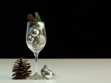 Bir bardakta gümüş süsler ve çam kozalakları bulunan şık bir Noel süsü. Bayram dekorasyonu için mükemmel..