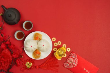 Çin Yeni Yılı için bereketli bir mantı, çay ve kırmızı zarflar düzenlemesi, refah ve neşeyi simgeliyor..