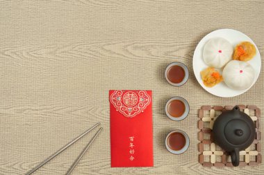 Çin Yeni Yılı 'nın neşe ve refahını kutlamak için hamur tatlısı, çay ve kırmızı zarflar sunan lezzetli bir ziyafet..