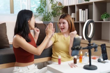 Eğlenceli bir makyaj seansından sonra sevinç ve heyecanı ifade eden genç kadınlar sosyal medya için anı yakalıyorlar..