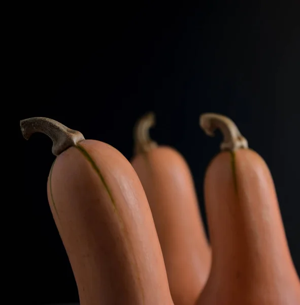 Kafası açıda kabak ezmesi, yiyecek manzarası tarzı ve koyu arkaplan ile hareket yaratıyor. Modern doğal yemek düzeni, yemek pornosu, hazırlık, hikaye anlatma konseptiyle yemek pişirme. Dikey resim.