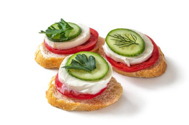 Sandwiches with cucumber, tomatoes, mozzarella and a sprig of dill isolated on white background