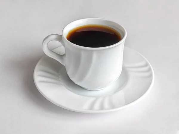 Cup of coffee, on a saucer from a coffee set made of white porcelain, on a light background