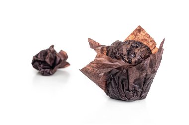 Parşömen kağıdında çikolatalı kek, beyaz arka planda izole edilmiş. Arka planda kullanılmış kahverengi ambalaj kağıdı var.