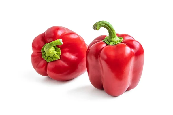 两只红色的 闪亮的 有浓密绿色枝干的辣椒 被白色背景隔开 — 图库照片