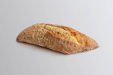 Keten tohumu ve susam tohumlu çavdar ekmeği, iştah açıcı bir kabuğun üstünde hafif bir zemin üzerinde bir kesik.