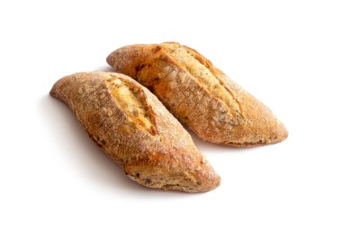 Çavdar ekmeği ve buğday unundan iki çörek, keten ve susam tohumlarıyla, tepesinde bir kesik, beyaz bir arka planda izole edilmiş.