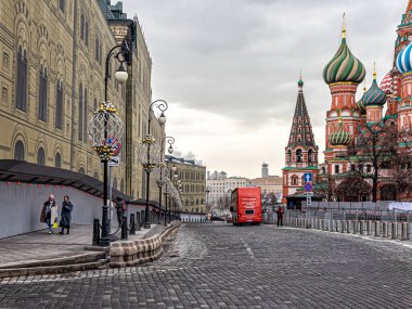 Moskova, Rusya, 03.18.2021. Kremlin Embankment 'a inin, St. Kubbe' ye. Basil Katedrali, kırmızı bir turist otobüsü ve koronavirüs salgını sırasında yalnız turistler.