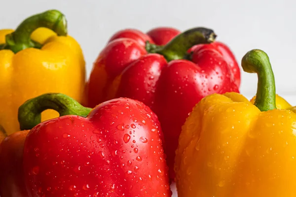 Bulgar biberleri, kırmızı ve sarı renkler, kenarlarında su damlaları var. Salata pişirmeden önce sebze yıkadım.