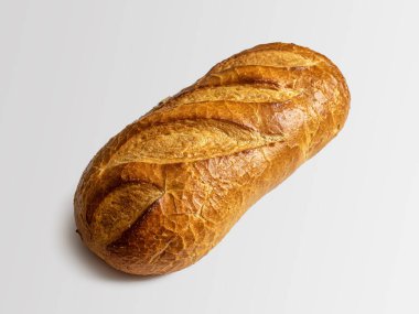 Loaf of white wheat flour bread, with a golden crust and slits on top, isolated on a white background