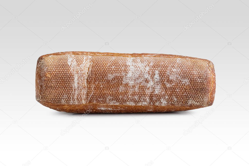 Textured, fried bottom crust of a floured mini baguette on a light background