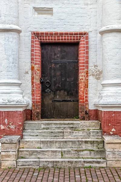 石砌的门廊通向两旁用柱子围成的锁着的木门 — 图库照片