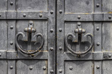 Metal levhalarla döşenmiş antik kapılar perçin ve demir saplarla döşenmiş demir şeritler. Kapılar birkaç kat siyah boya ile boyanmış.