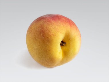 Beyaz arka planda kadife gibi sarı-kırmızı bir teni olan tatlı sulu şeftali.