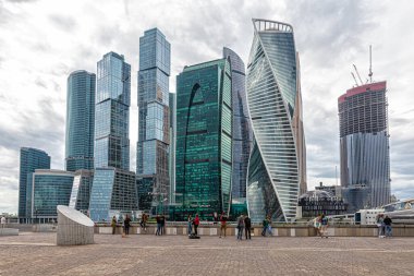 Moskova, Rusya, 07.23.2021. İnsanlar Moskova Nehri 'nin diğer tarafındaki Moskova şehrinin iş merkezinin önünde, gözlem güvertesinde fotoğraf çekip selfie çekiyorlar.