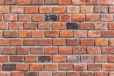 Eski bir tuğla duvar. Arka plan, beton harçla birbirine tutturulmuş kırmızı tuğladan yapılmış.