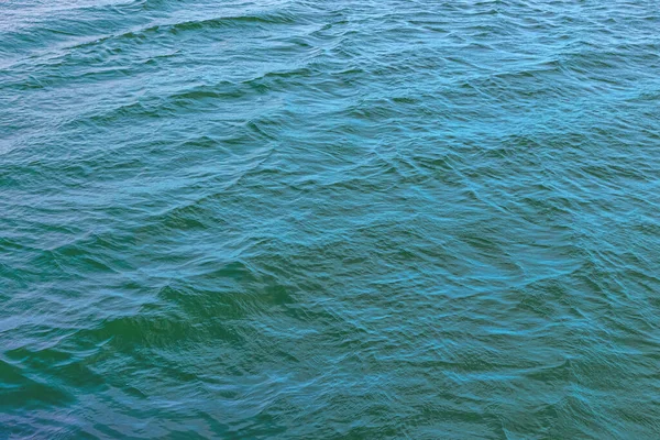 Small waves and ripples on the blue-green surface of the sea in calm weather