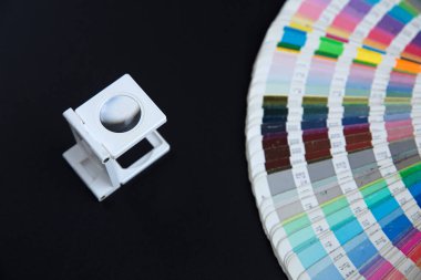 Renk yönetimine basın. Siyah arkaplanda Cmyk çizgili loupe ve renk paleti.