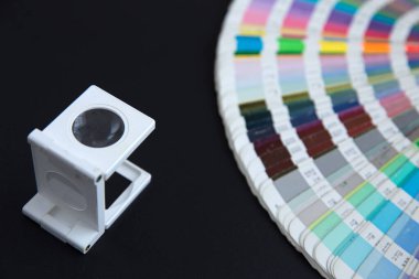Renk yönetimine basın. Siyah arkaplanda Cmyk çizgili loupe ve renk paleti.