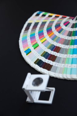 Renk yönetimine basın. Siyah arkaplanda Cmyk çizgili loupe ve renk paleti.