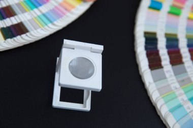 Renk yönetimine basın. Siyah arkaplanda Cmyk çizgili loupe ve renk paleti.