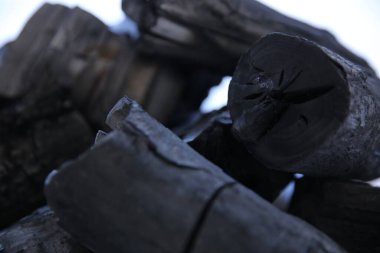 Beyaz arkaplanda siyah odun kömürü yığını.