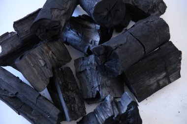 Beyaz arkaplanda siyah odun kömürü yığını.
