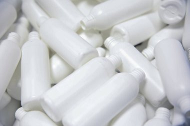 Arka plan olarak boş beyaz plastik şişeler yığını. 