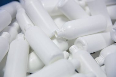 Arka plan olarak boş beyaz plastik şişeler yığını. 