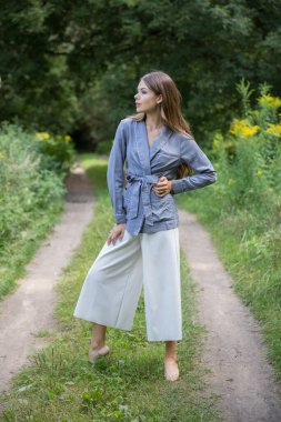 Güzel bir esmer yaz ormanı yolunda duruyor..