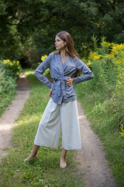 Güzel bir esmer yaz ormanı yolunda duruyor..